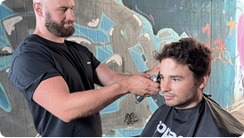 Barber cutting client's hair in a stylish setting